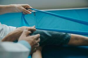 Doctor or physical therapist examines back pain and spinal area to give advice within the rehabilitation center. photo