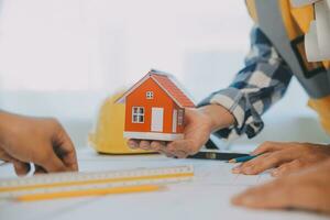 Construction and structure concept of Engineer or architect meeting for project working with partner and engineering tools on model building and blueprint in working site, contract for both companies. photo