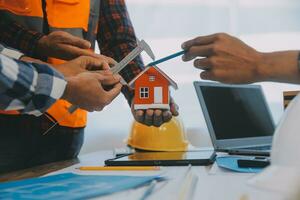 Construction and structure concept of Engineer or architect meeting for project working with partner and engineering tools on model building and blueprint in working site, contract for both companies. photo