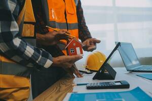Construction and structure concept of Engineer or architect meeting for project working with partner and engineering tools on model building and blueprint in working site, contract for both companies. photo