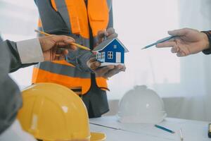 Construction and structure concept of Engineer or architect meeting for project working with partner and engineering tools on model building and blueprint in working site, contract for both companies. photo