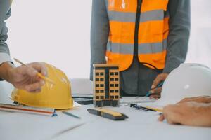 Construction and structure concept of Engineer or architect meeting for project working with partner and engineering tools on model building and blueprint in working site, contract for both companies. photo