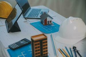 Construction and structure concept of Engineer or architect meeting for project working with partner and engineering tools on model building and blueprint in working site, contract for both companies. photo