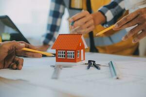 Construction and structure concept of Engineer or architect meeting for project working with partner and engineering tools on model building and blueprint in working site, contract for both companies. photo