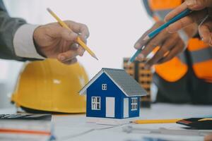 Construction and structure concept of Engineer or architect meeting for project working with partner and engineering tools on model building and blueprint in working site, contract for both companies. photo