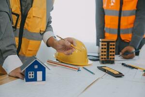 Construction and structure concept of Engineer or architect meeting for project working with partner and engineering tools on model building and blueprint in working site, contract for both companies. photo