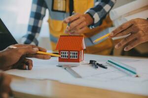 Construction and structure concept of Engineer or architect meeting for project working with partner and engineering tools on model building and blueprint in working site, contract for both companies. photo