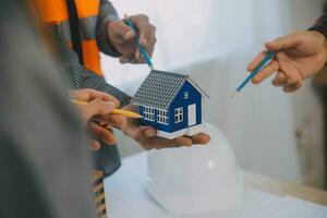 Construction and structure concept of Engineer or architect meeting for project working with partner and engineering tools on model building and blueprint in working site, contract for both companies. photo