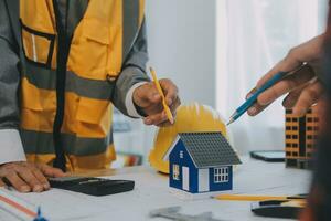 Construction and structure concept of Engineer or architect meeting for project working with partner and engineering tools on model building and blueprint in working site, contract for both companies. photo