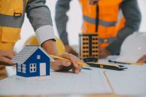 Construction and structure concept of Engineer or architect meeting for project working with partner and engineering tools on model building and blueprint in working site, contract for both companies. photo