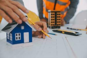 Construction and structure concept of Engineer or architect meeting for project working with partner and engineering tools on model building and blueprint in working site, contract for both companies. photo