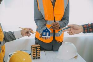 Construction and structure concept of Engineer or architect meeting for project working with partner and engineering tools on model building and blueprint in working site, contract for both companies. photo
