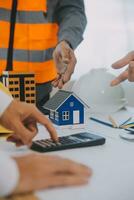 Construction and structure concept of Engineer or architect meeting for project working with partner and engineering tools on model building and blueprint in working site, contract for both companies. photo