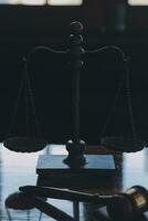 Justice and law concept.Male judge in a courtroom with the gavel, working with, computer and docking keyboard, eyeglasses, on table in morning light photo