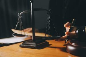 law books and scales of justice on desk in library of law firm. jurisprudence legal education concept. photo