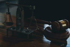 law books and scales of justice on desk in library of law firm. jurisprudence legal education concept. photo