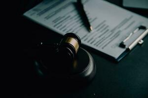 Business and lawyers discussing contract papers with brass scale on desk in office. Law, legal services, advice, justice and law concept picture with film grain effect photo