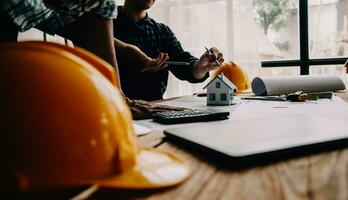 Construction and structure concept of Engineer or architect meeting for project working with partner and engineering tools on model building and blueprint in working site, contract for both companies. photo
