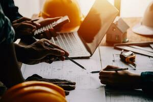 Construction and structure concept of Engineer or architect meeting for project working with partner and engineering tools on model building and blueprint in working site, contract for both companies. photo