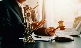 Business and lawyers discussing contract papers with brass scale on desk in office. Law, legal services, advice, justice and law concept picture with film grain effect photo