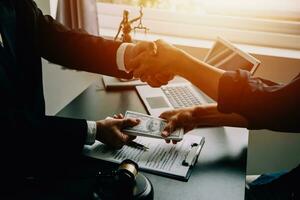 Business and lawyers discussing contract papers with brass scale on desk in office. Law, legal services, advice, justice and law concept picture with film grain effect photo