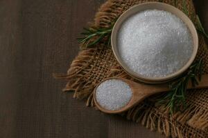 white sugar in bowl on wood background, white sugar adds flavor to desserts and baked photo