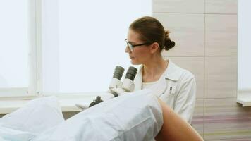 Female Gynecologist examining patient on chair with gynecological equipment. Colposcopy, examination of a cervical cancer. Colposcope close-up. Maternity fertility IVF issues. Abortion and ovulation video