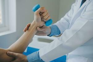 Doctor or physical therapist examines back pain and spinal area to give advice within the rehabilitation center. photo