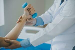 Doctor or physical therapist examines back pain and spinal area to give advice within the rehabilitation center. photo