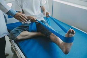 Doctor or physical therapist examines back pain and spinal area to give advice within the rehabilitation center. photo