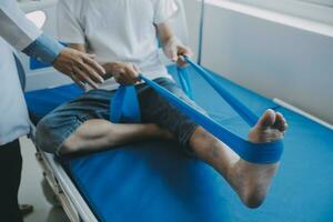 Doctor or physical therapist examines back pain and spinal area to give advice within the rehabilitation center. photo