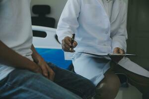 Doctor or physical therapist examines back pain and spinal area to give advice within the rehabilitation center. photo