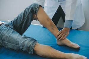 Doctor or physical therapist examines back pain and spinal area to give advice within the rehabilitation center. photo