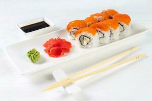 Sushi roll Philadelphia with salmon, smoked eel, avocado, cream cheese on white background photo