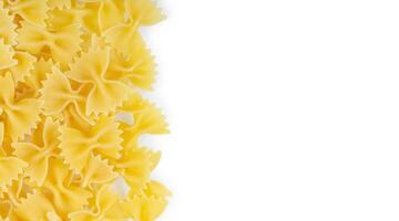 Scattered raw pasta farfalle isolated on white background. Food background, italian cuisine photo