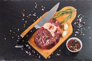 meat steak and cooking ingredients on black background photo