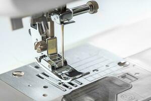 Modern white sewing machine presser foot closeup, macro photo