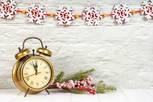 Decorative Christmas tree and alarm clock on white brick wall background. photo