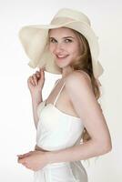 Portrait of happiness woman wearing floppy sun hat, cupped corset top and pants. Headshot, side view photo