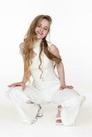 Smiling woman with eyes closed sits squatting position put both hands on knees on white background photo