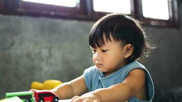 Boy plays with toy car at home. Kid Playing With Colorful Toy. Boy plays in playroom with educational toys. video