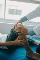 Doctor or physical therapist examines back pain and spinal area to give advice within the rehabilitation center. photo