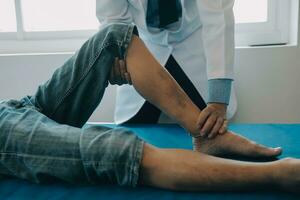 Doctor or physical therapist examines back pain and spinal area to give advice within the rehabilitation center. photo