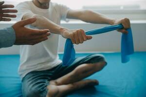 Doctor or physical therapist examines back pain and spinal area to give advice within the rehabilitation center. photo