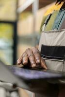 Warehouse supervisor looking at cargo stock on laptop computer before start preparing customers orders, checking shipping details, Manager working in delivery department, distribution center concept photo