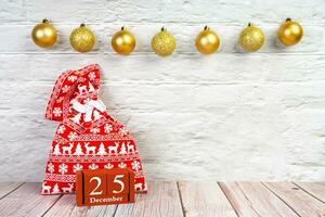 Christmas red gift bag with Christmas pattern with red wooden perpetual calendar photo