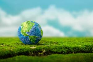 World Earth Day Concept. Green Energy, ESG, Renewable and Sustainable Resources. Environmental Care. Globe on Green Moss and blurred Sky as background photo