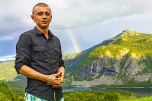 joven hombre modelo posando en frente de montaña arco iris Noruega. foto