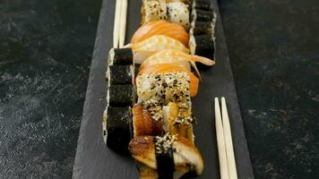 rollos de tradicional Sushi en negro Roca lámina. muñequita diapositiva paralaje tipo imágenes video
