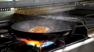 Cooking a piece of duck breast meat on the pan in kitchen restaurant video